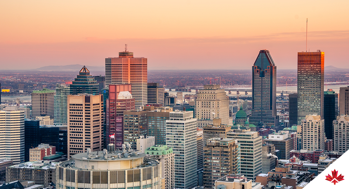 Coucher de soleil sur le paysage urbain de Montréal avec des gratte-ciel et le fleuve Saint-Laurent visible en arrière-plan.