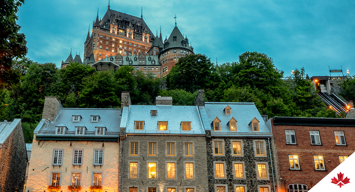 Le château Frontenac historique au-dessus des restaurants et des magasins dans la vieille ville de Québec, Canada, dans la lumière de début de soirée.