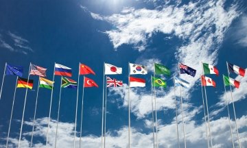 Ciel bleu nuageux avec les drapeaux des pays membres du G20.